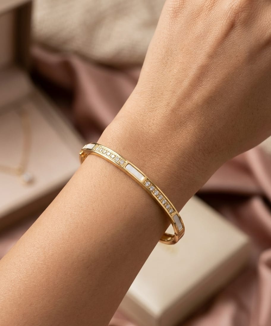 Gold-colour cuff bracelet with white centre and clear stone lines