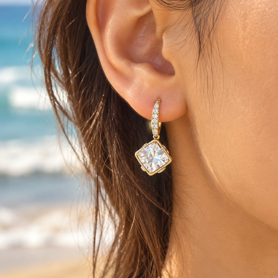 Square Crystal gold-tone earrings worn on a beach