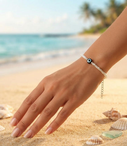 White bead bracelet with black evil eye charm