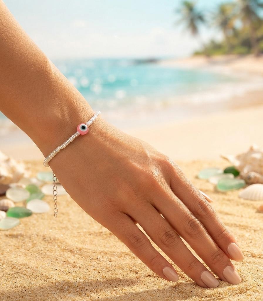 White bead bracelet with pink evil eye charm
