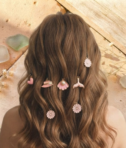 Five pink decorative hair pins styled in hair