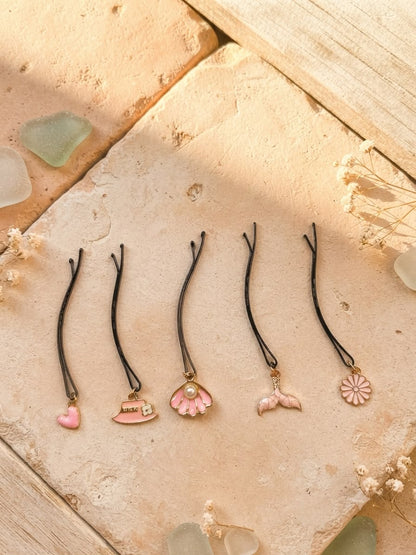 Five pink decorative hair pins displayed individually