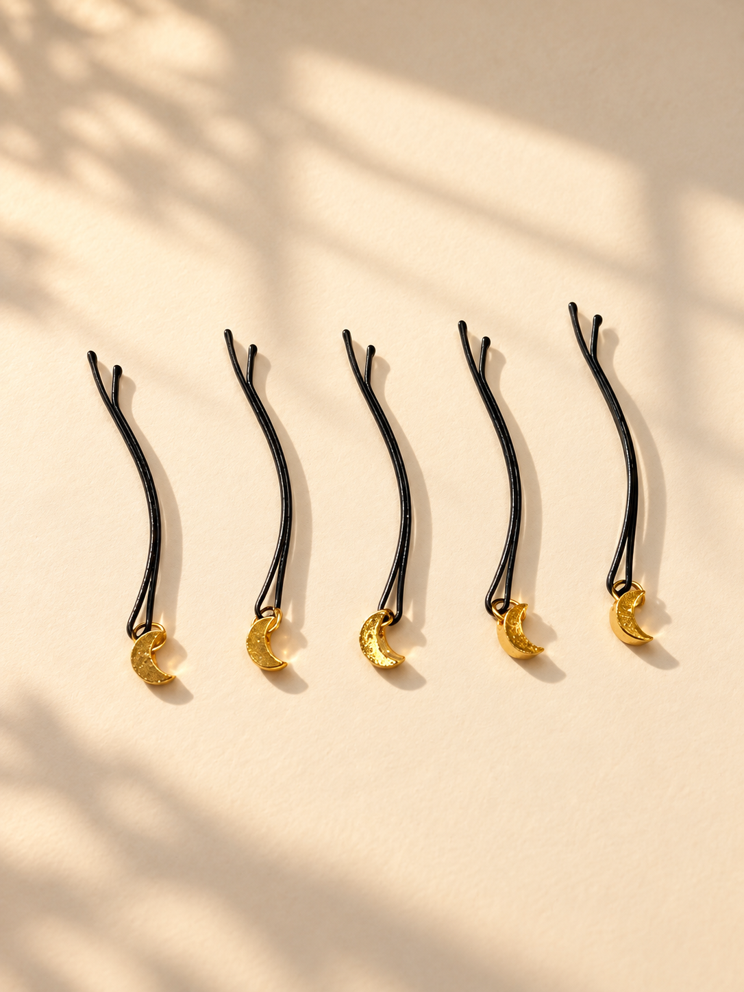Gold glitter crescent hair pins displayed individually