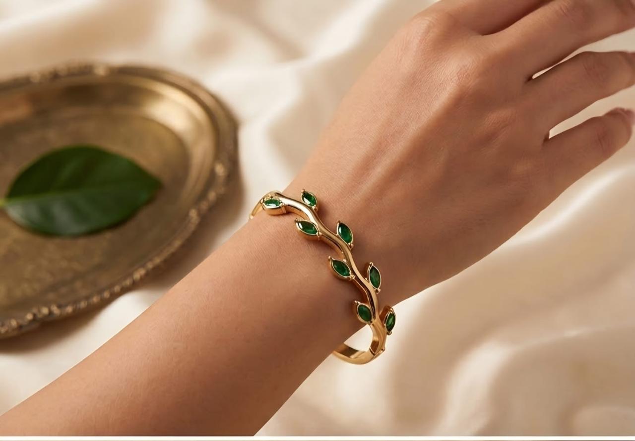 Gold-colour bracelet with green leaf-shaped stones
