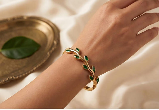 Gold-colour bracelet with green leaf-shaped stones