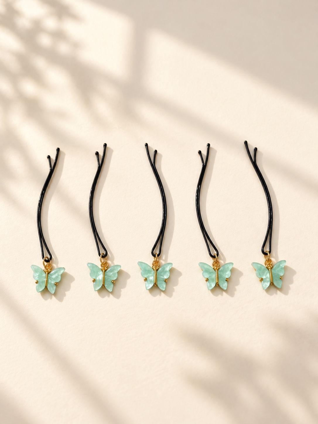 Mint butterfly charm hair pins displayed individually