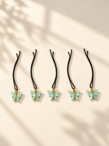 Mint butterfly charm hair pins displayed individually